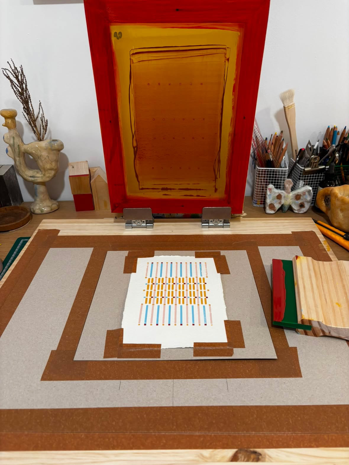The printing table in oso’s studio with a screen and squeegee